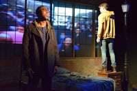 two men standing in a room with a projection screen